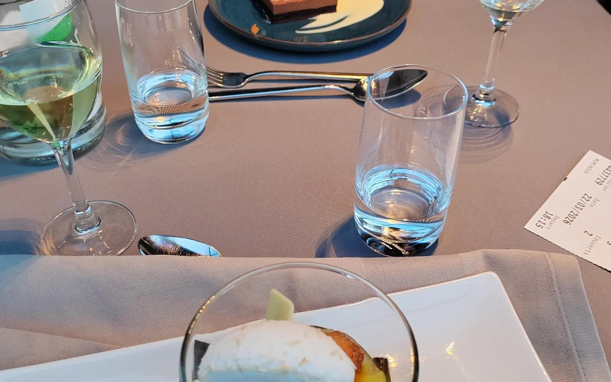 A laid dinner table beside the panoramic window of a Seine cruise boat in Paris