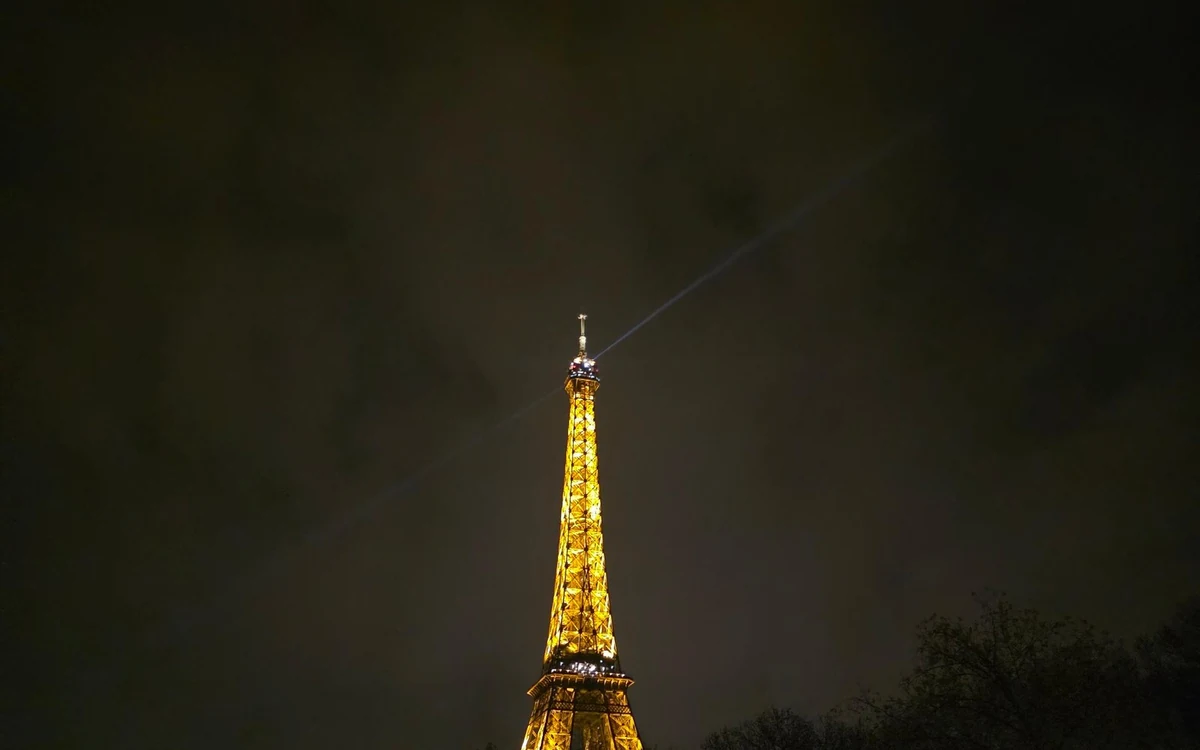 A table laid for two beside the window of a Seine dinner cruise boat in Paris at night