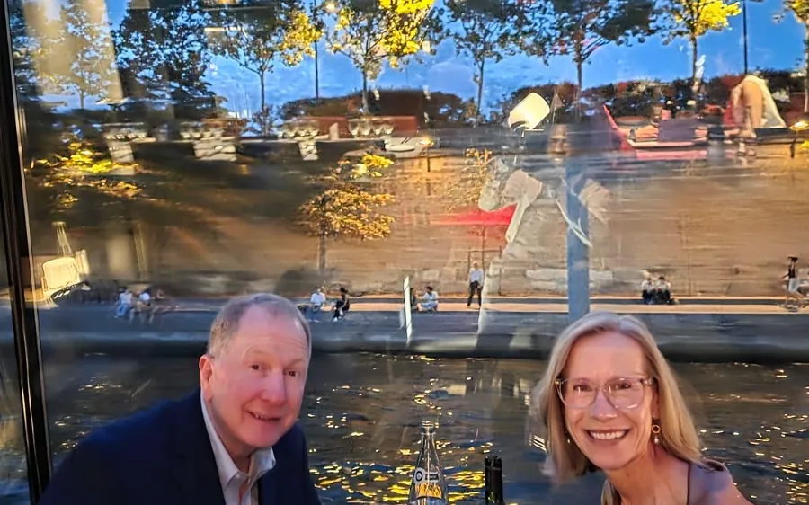 A table set by the window of a dinner cruise boat on the Seine